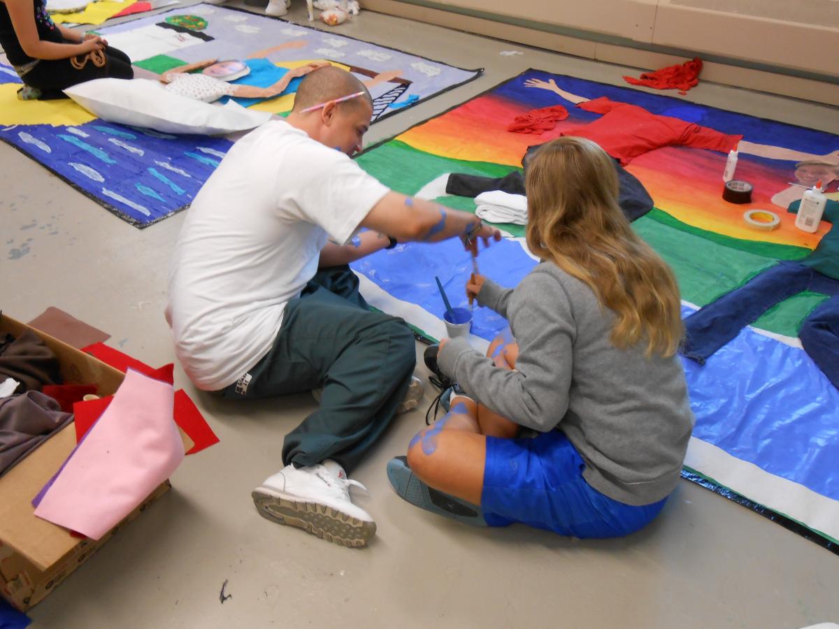 father and daughter making a mural
