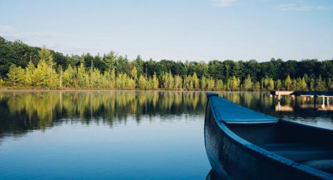 Photo of a lake with canoe in corner