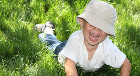 Child laying in grass