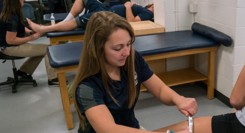 UNH Health Sciences student working with a student athlete