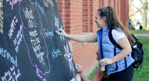 girl writing on blackboard