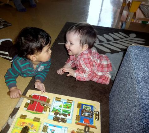 two infants playing in classroom