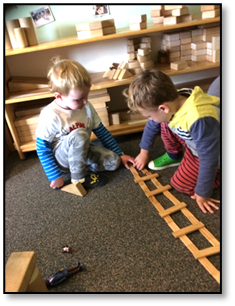2 kids playing with wooden structures