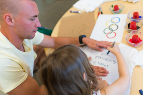 Teacher assisting student with writing