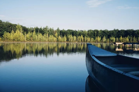 Canoe in quiet lake surrounded by trees