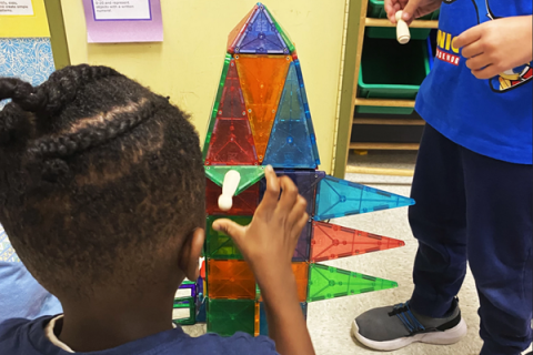 Child building tower with magnatiles