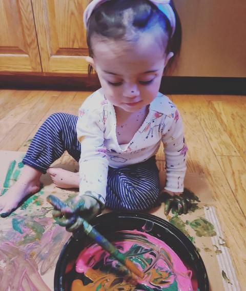 Toddler painting on cardboard